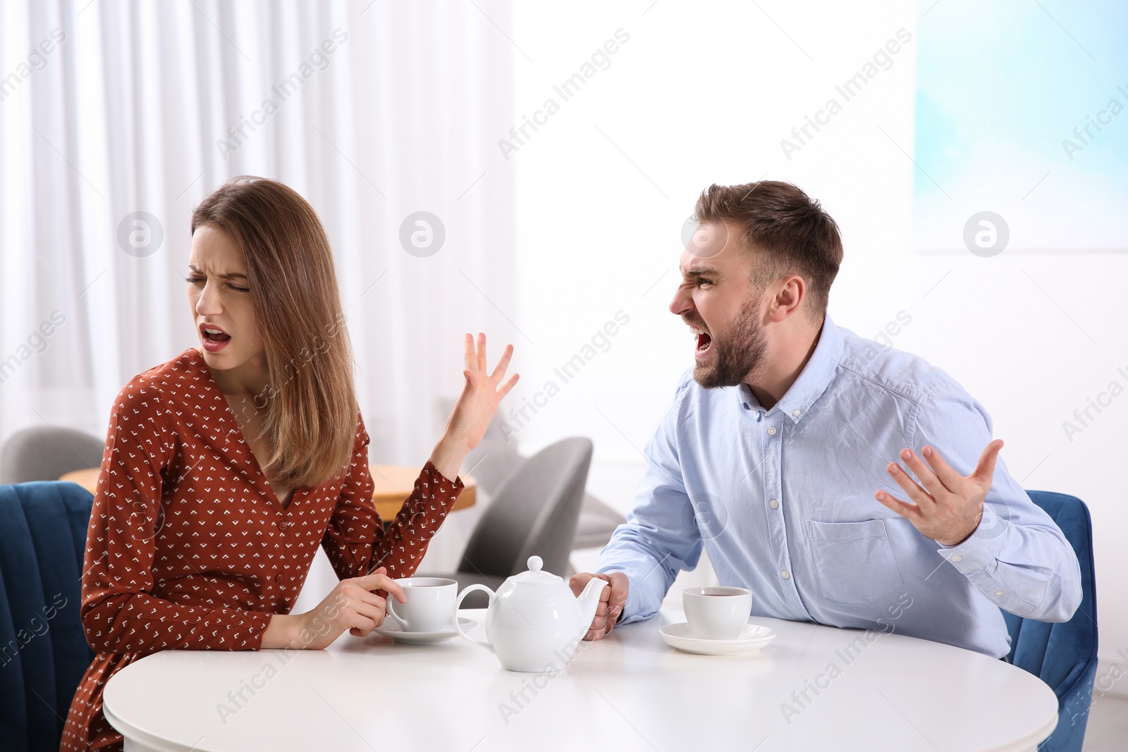 Photo of Couple having quarrel in cafe. Relationship problems