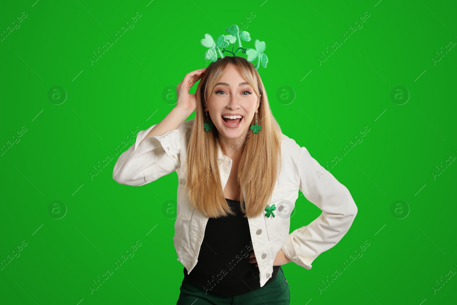 Image of Happy woman in St. Patrick's Day outfit on green background