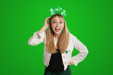 Image of Happy woman in St. Patrick's Day outfit on green background