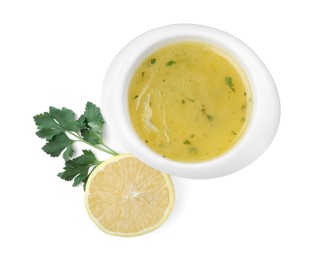 Photo of Bowl with lemon sauce and ingredients on white background, top view. Delicious salad dressing