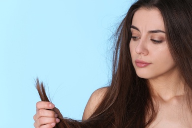 Woman with damaged hair and space for text on color background. Split ends