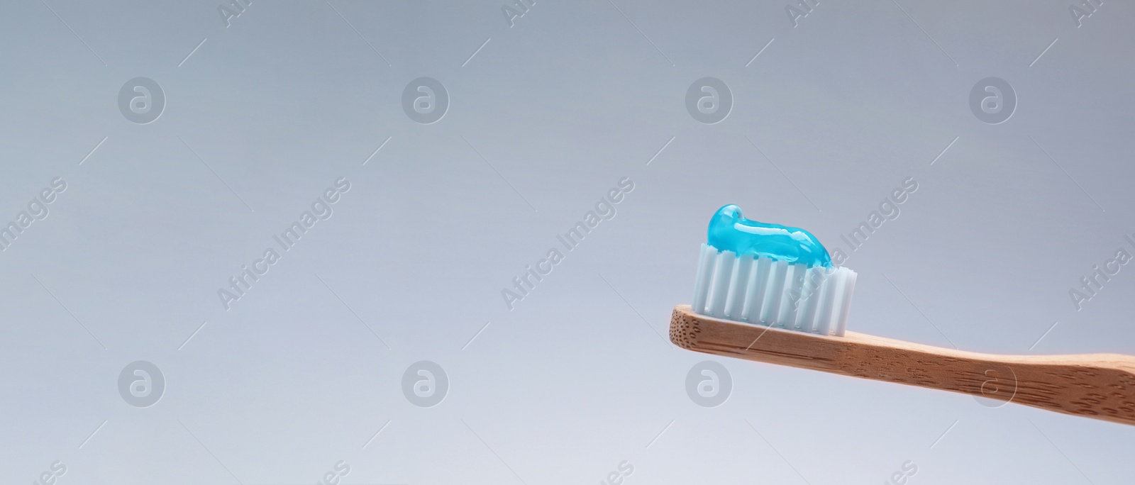 Image of Brush with toothpaste on grey background, space for text. Banner design