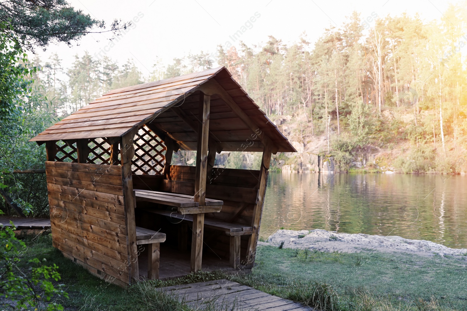 Photo of Wooden gazebo near lake. Camping season