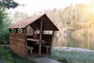 Photo of Wooden gazebo near lake. Camping season