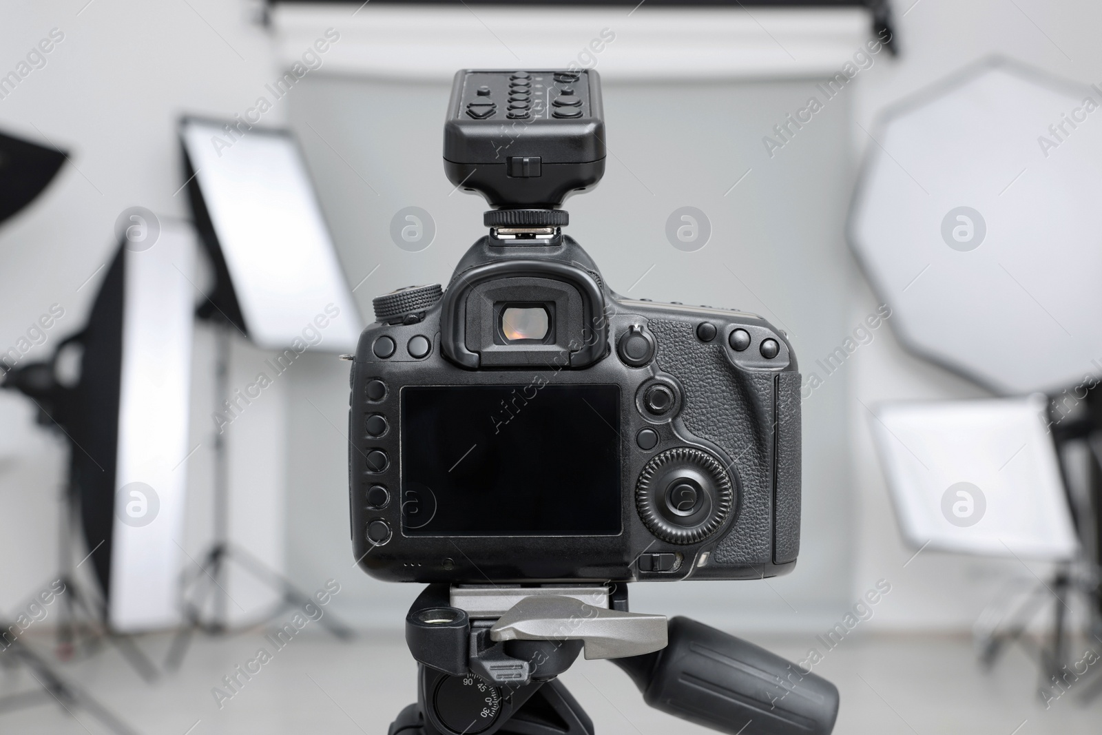 Photo of Camera on tripod and professional lighting equipment in modern photo studio, closeup