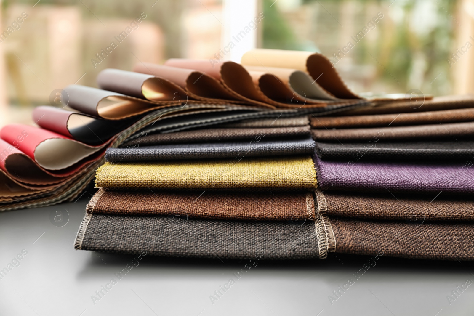 Photo of Fabric and leather samples of different colors for interior design on table