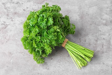 Photo of Bunch of fresh green parsley on grey background