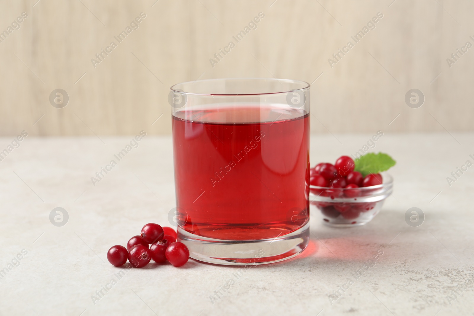 Photo of Tasty refreshing cranberry juice and fresh berries on light table