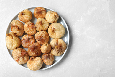 Photo of Tasty dried figs on light grey marble table, top view. Space for text