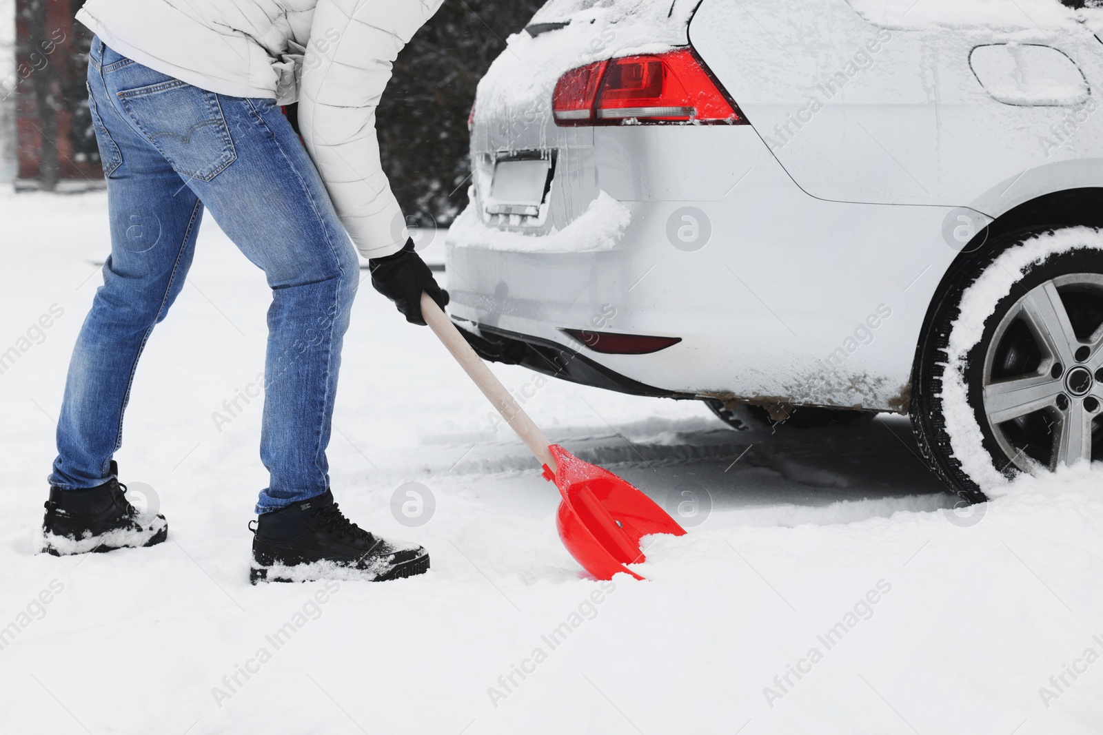 Photo of Man removing snow with shovel near car outdoors, closeup