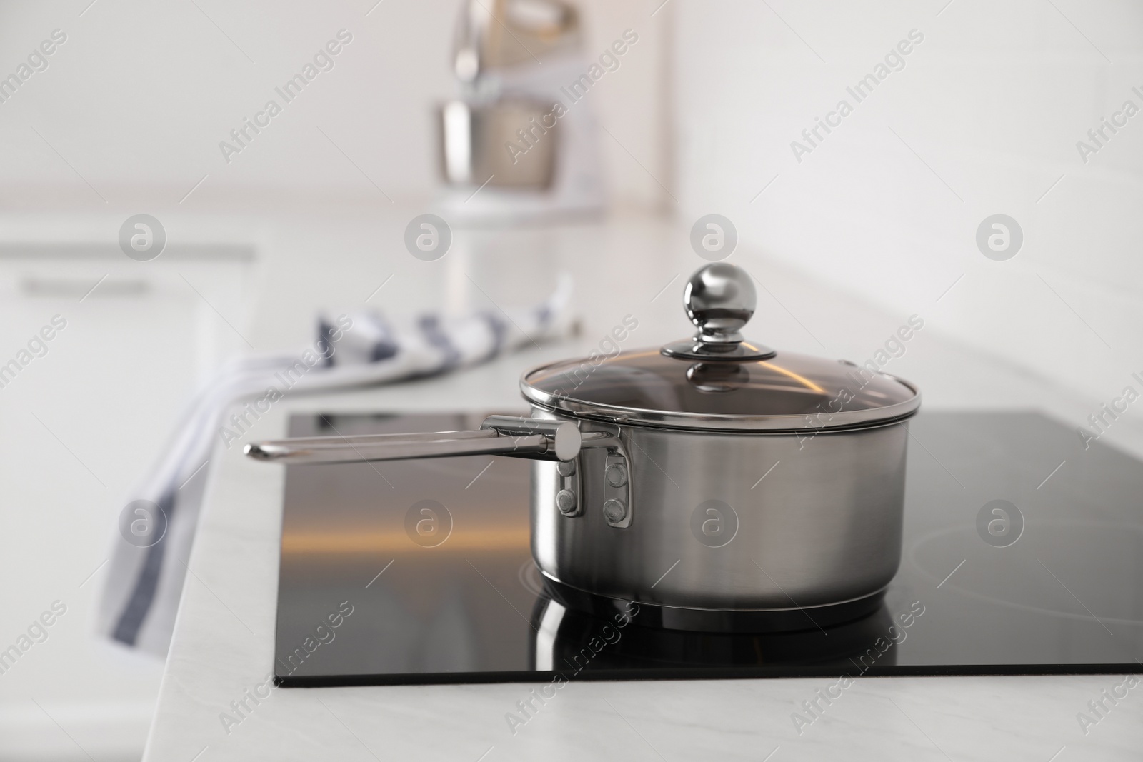 Photo of New clean saucepan on cooktop in kitchen