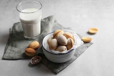 Photo of Delicious walnut shaped cookies with filling and milk on grey table