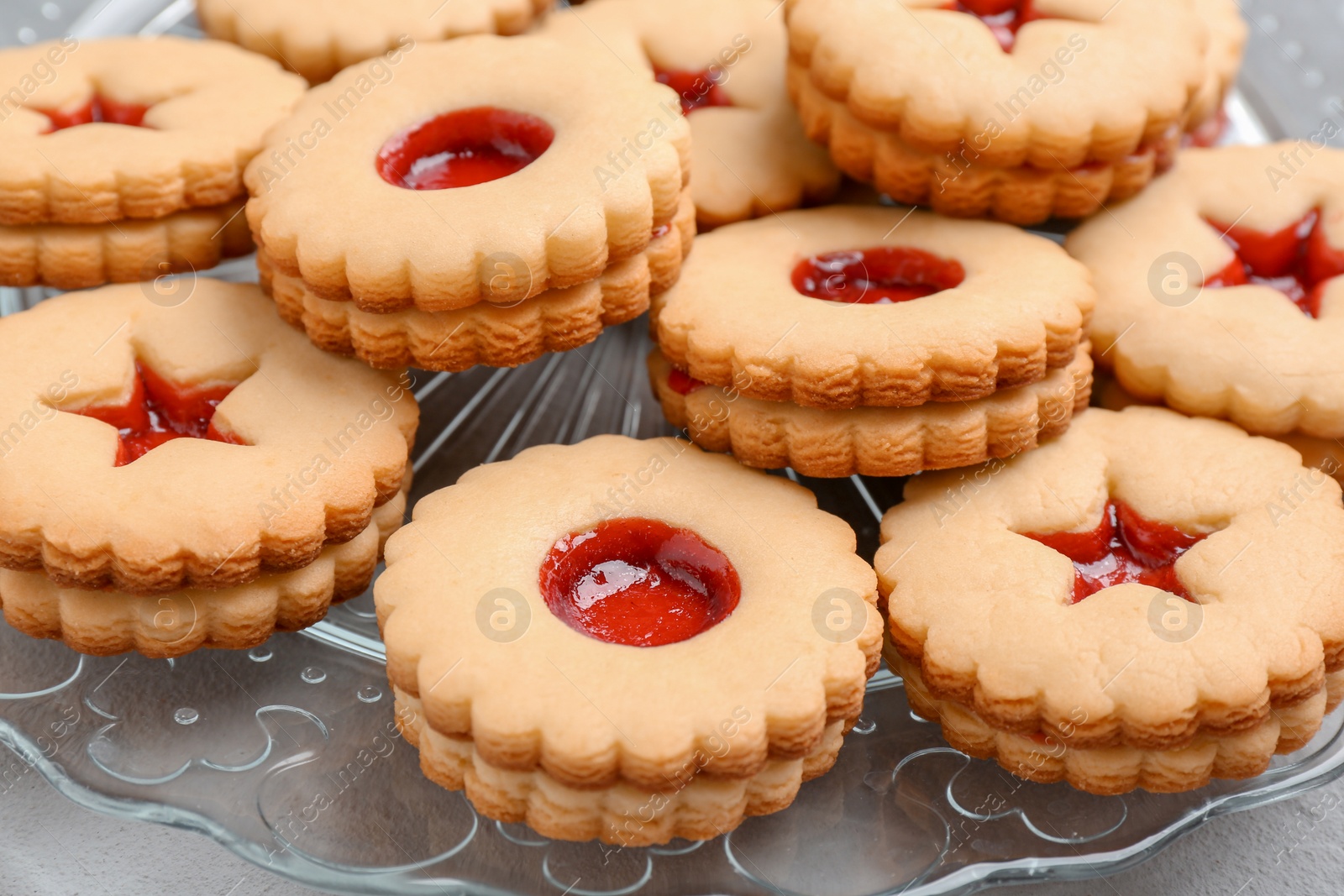 Photo of Traditional Christmas Linzer cookies with sweet jam on plate, closeup