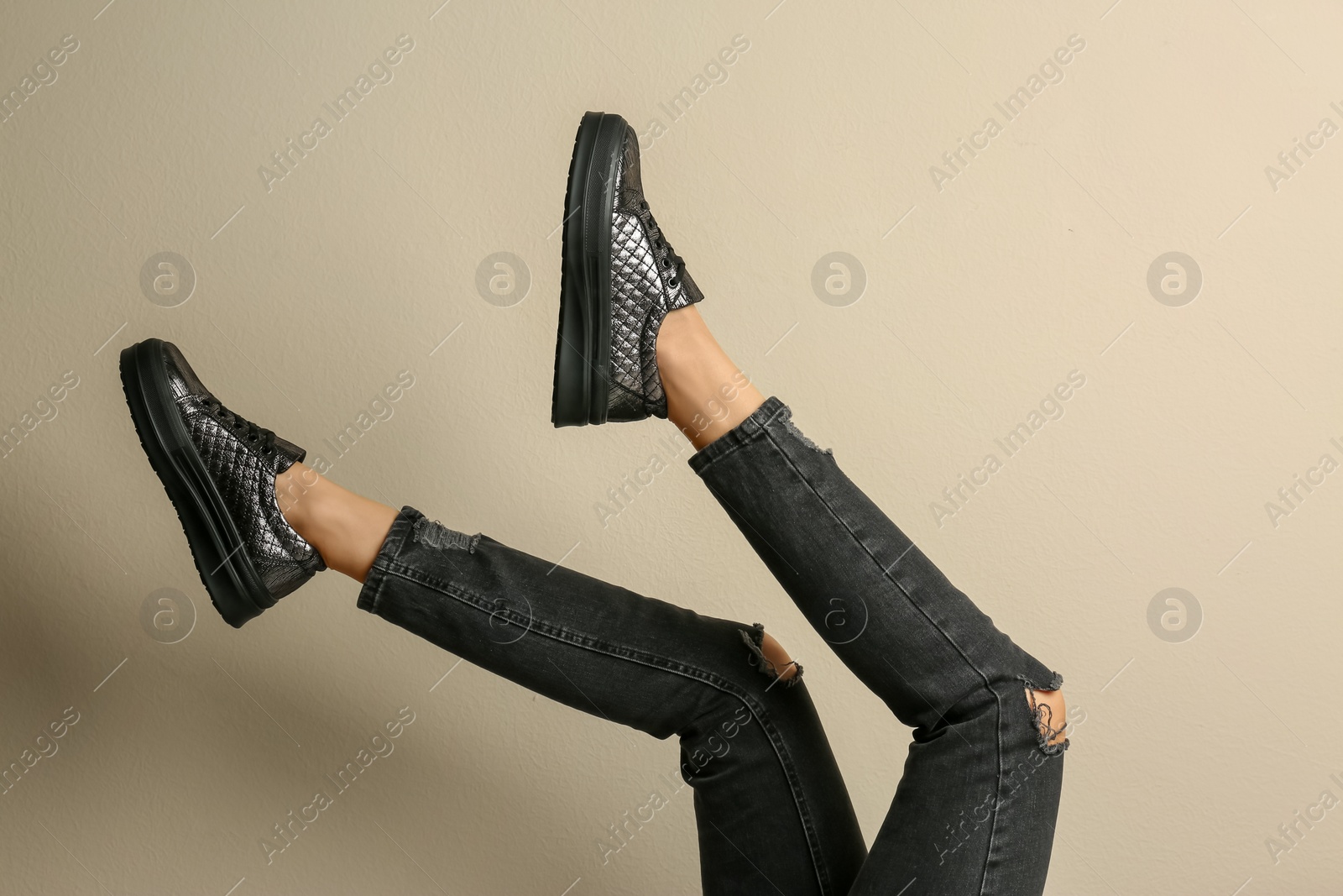 Photo of Woman wearing shoes on beige background, closeup