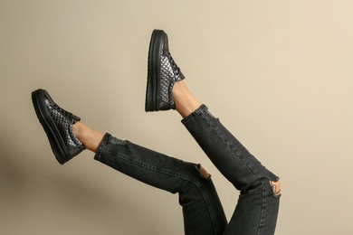 Photo of Woman wearing shoes on beige background, closeup