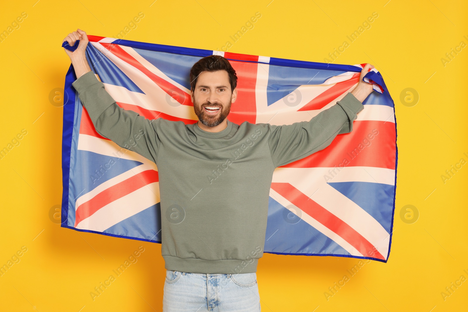 Photo of Man with flag of United Kingdom on yellow background