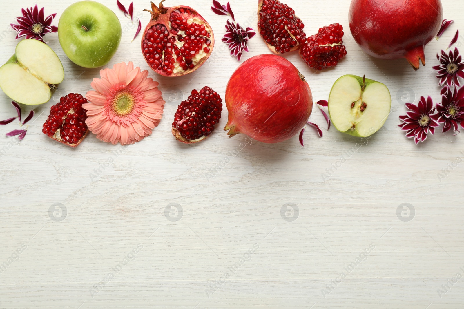 Photo of Flat lay composition with Rosh Hashanah holiday attributes on white wooden table. Space for text