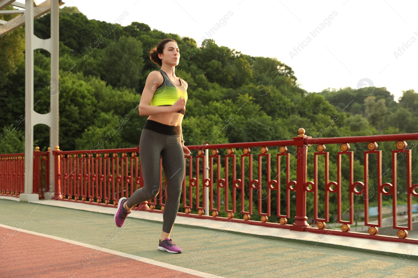Photo of Beautiful sporty young woman running in city