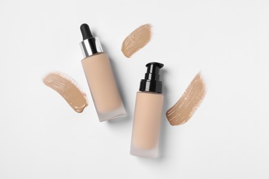 Photo of Liquid foundations and swatches on white background, flat lay