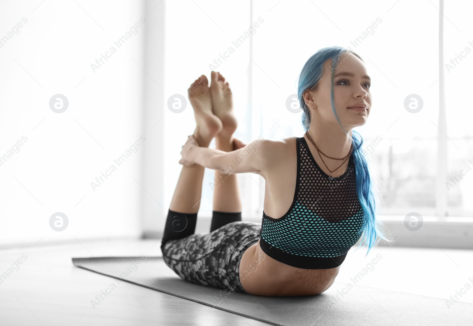 Photo of Young woman practicing yoga indoors