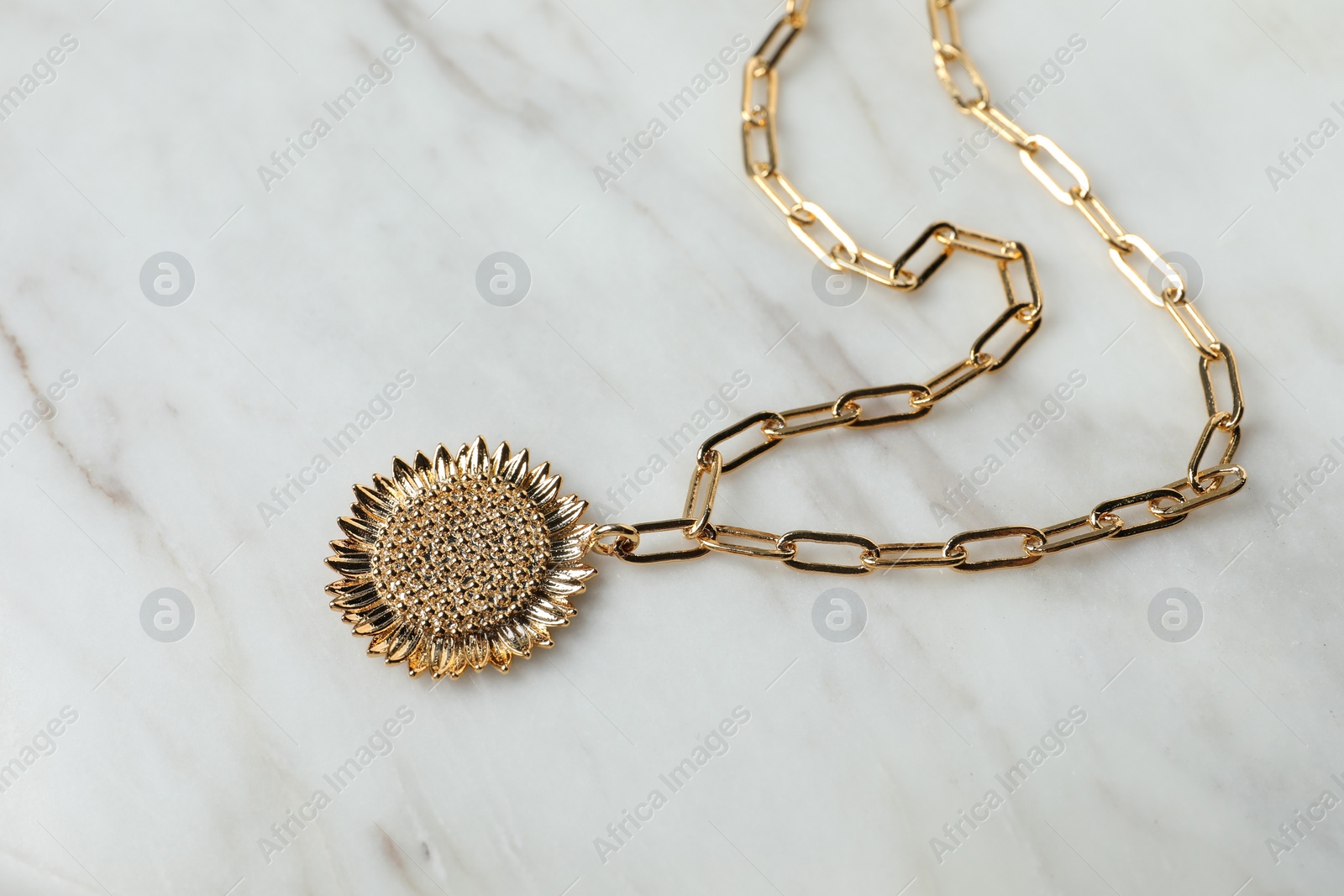 Photo of Necklace on white marble table, closeup view