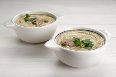 Delicious mushroom cream soup with parsley on white wooden table