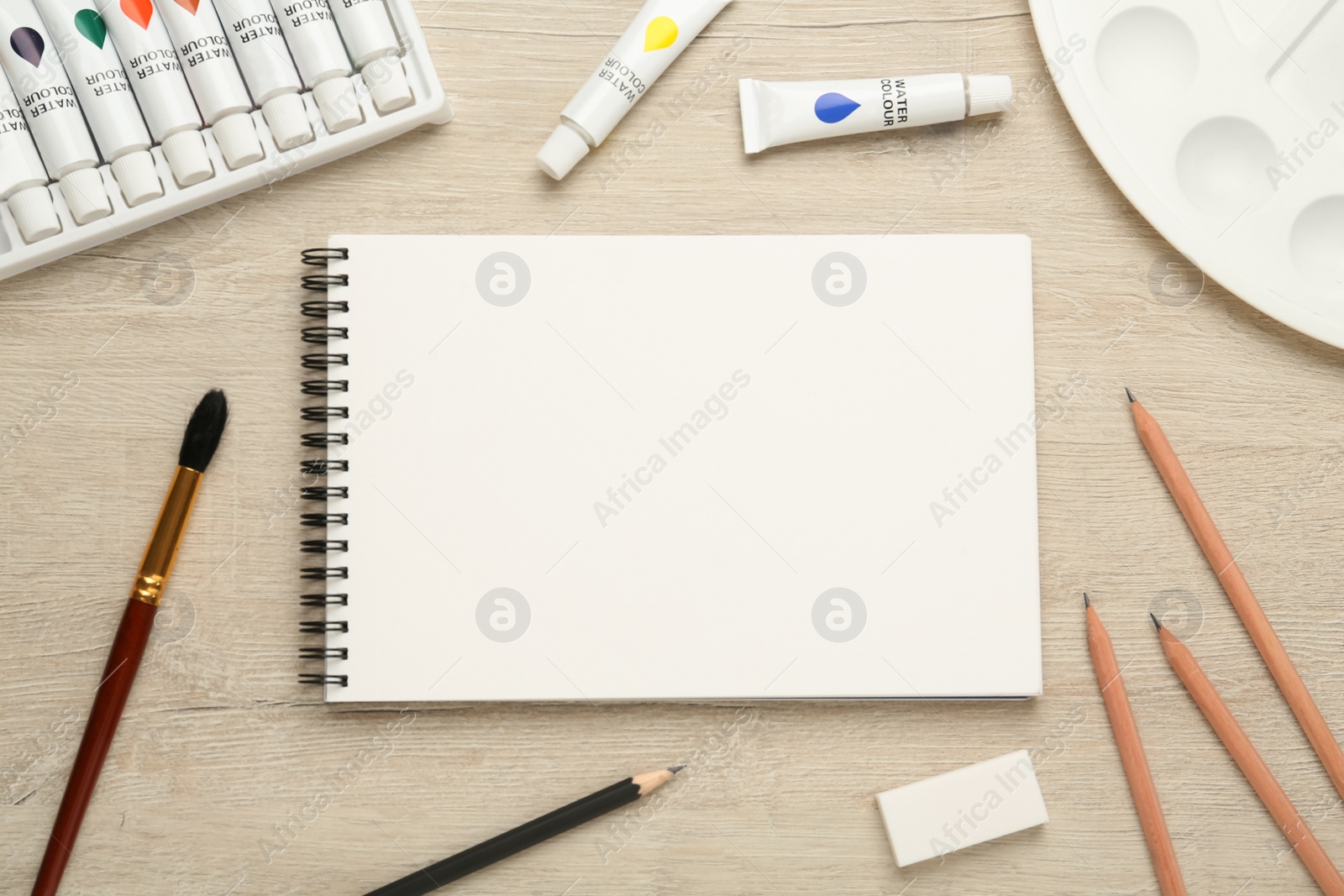 Photo of Flat lay composition with blank sketchbook on wooden table. Space for text