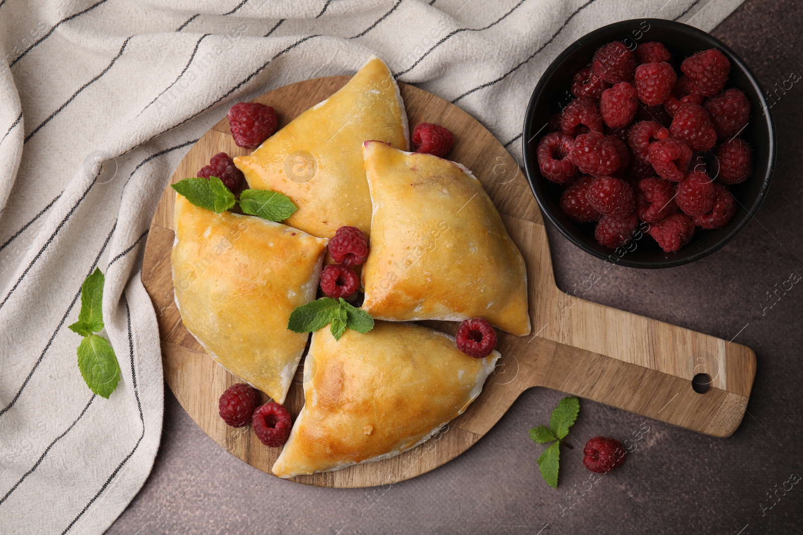 Photo of Delicious samosas with raspberries on grey table, flat lay