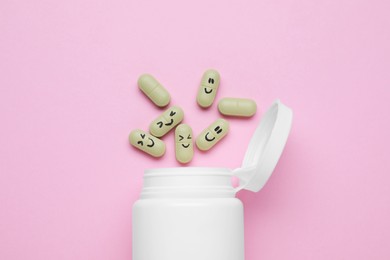 Bottle and antidepressant pills with funny faces on pink background, flat lay