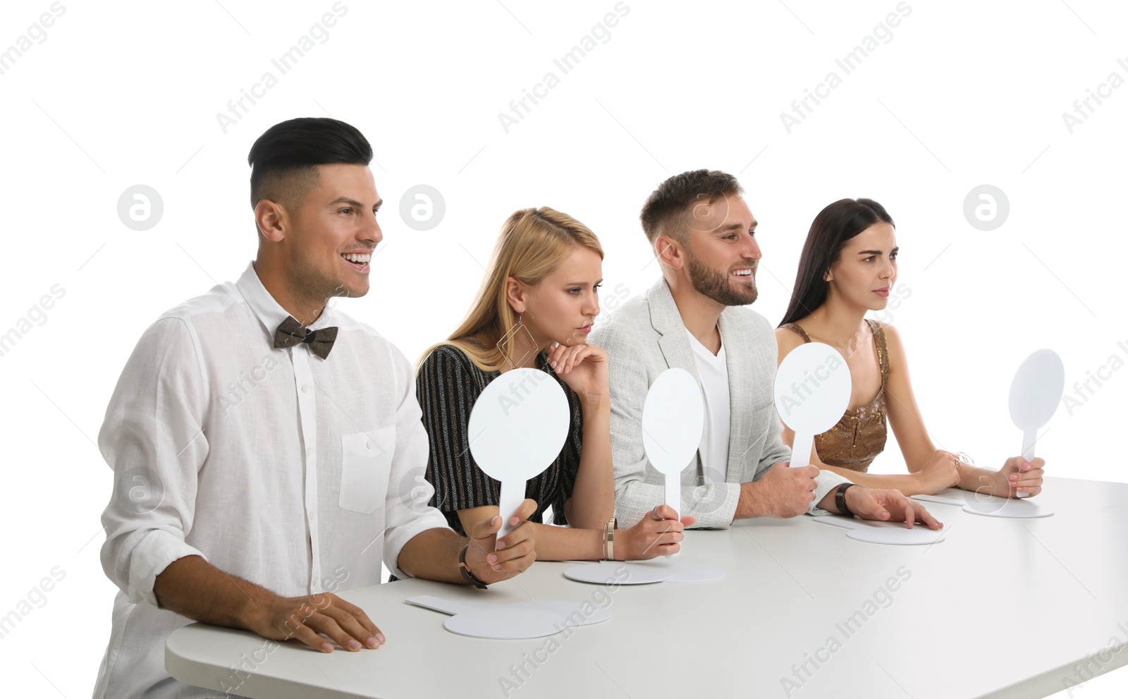 Photo of Panel of judges with different emotions holding blank signs at table on white background. Space for text