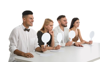 Photo of Panel of judges with different emotions holding blank signs at table on white background. Space for text