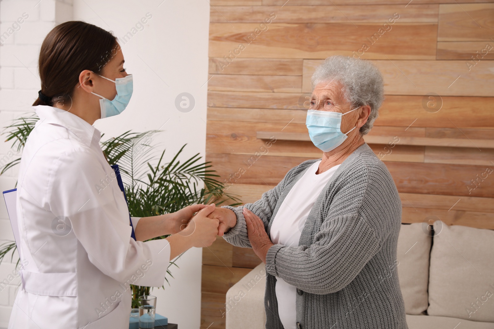 Photo of Doctor taking care of senior woman with protective mask at nursing home