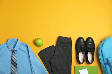 Photo of Flat lay composition with school uniform on yellow background. Space for text