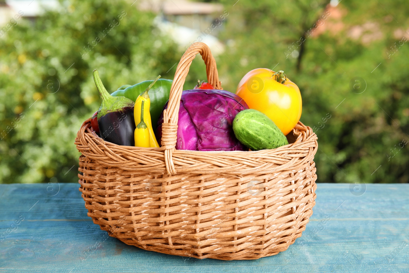 Photo of Wicker basket with fresh ripe vegetables on table. Organic food