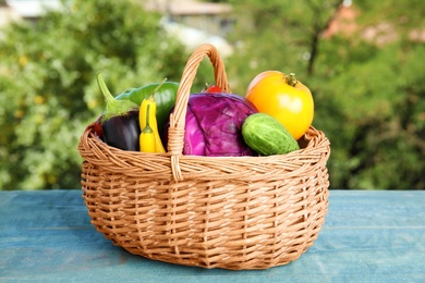 Wicker basket with fresh ripe vegetables on table. Organic food