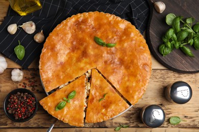 Photo of Delicious meat pie served on wooden table, flat lay