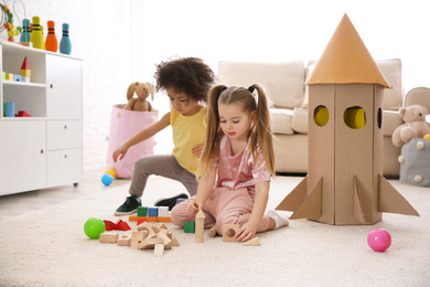 Photo of Cute little children playing with blocks at home