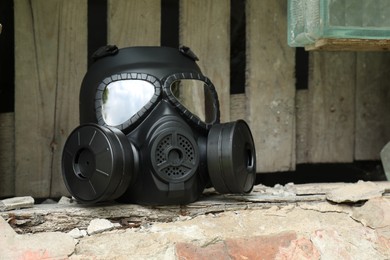 Photo of One gas mask on stone surface outdoors. Safety equipment