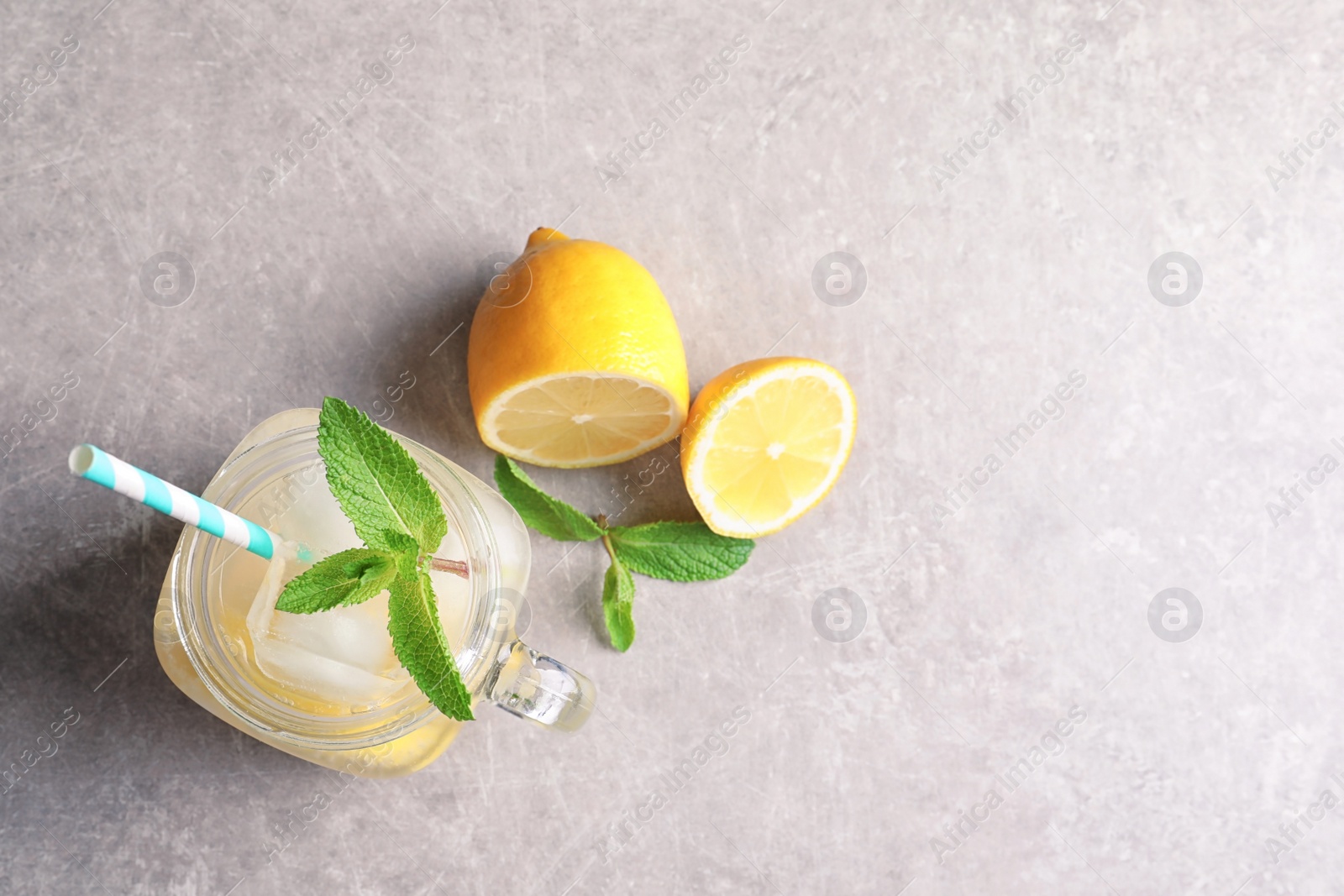 Photo of Refreshing natural lemonade in mason jar on table, flat lay