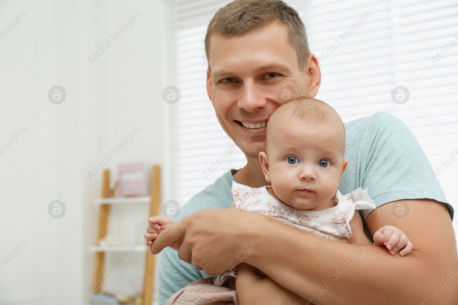 Photo of Happy father with his little baby at home. Space for text