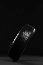 Photo of New car tire on black background