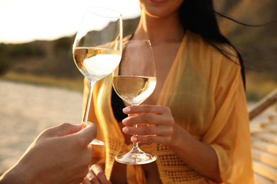 Photo of Romantic couple drinking wine together on beach, closeup