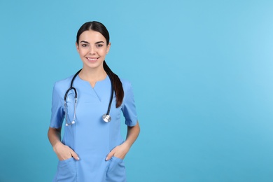 Photo of Portrait of medical assistant with stethoscope on color background. Space for text