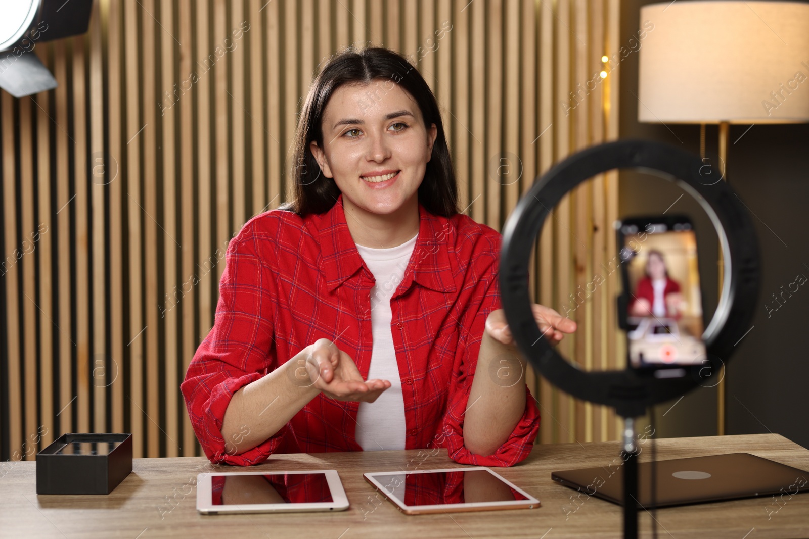 Photo of Smiling technology blogger recording video review about tablets at home