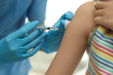 Photo of Doctor vaccinating little child in clinic, closeup