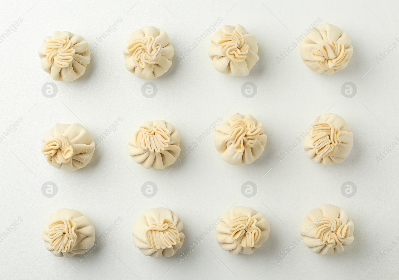 Photo of Composition with raw dumplings on white background, top view