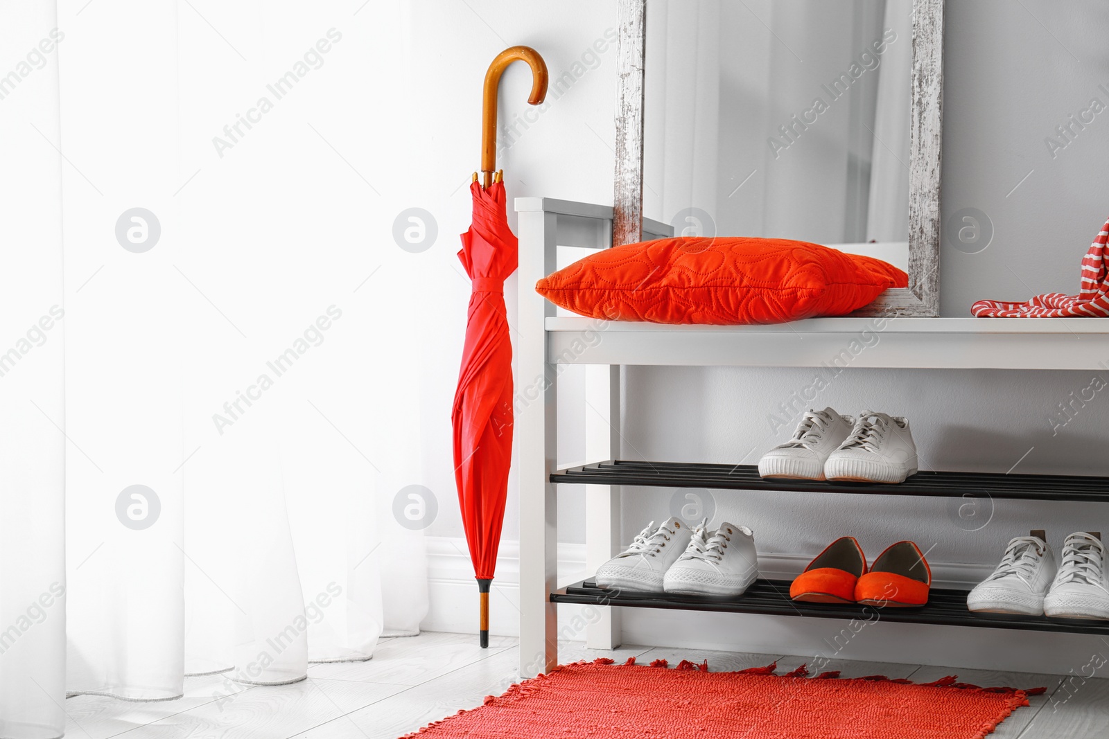 Stylish hallway interior with shoe rack and rug. Space for text Photo of Stylish hallway interior with shoe rack and rug. Space for text
