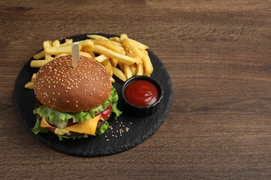 Photo of Delicious burger with beef patty, tomato sauce and french fries on wooden table, above view. Space for text