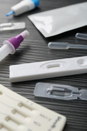 Disposable express test kits on black wooden table, closeup