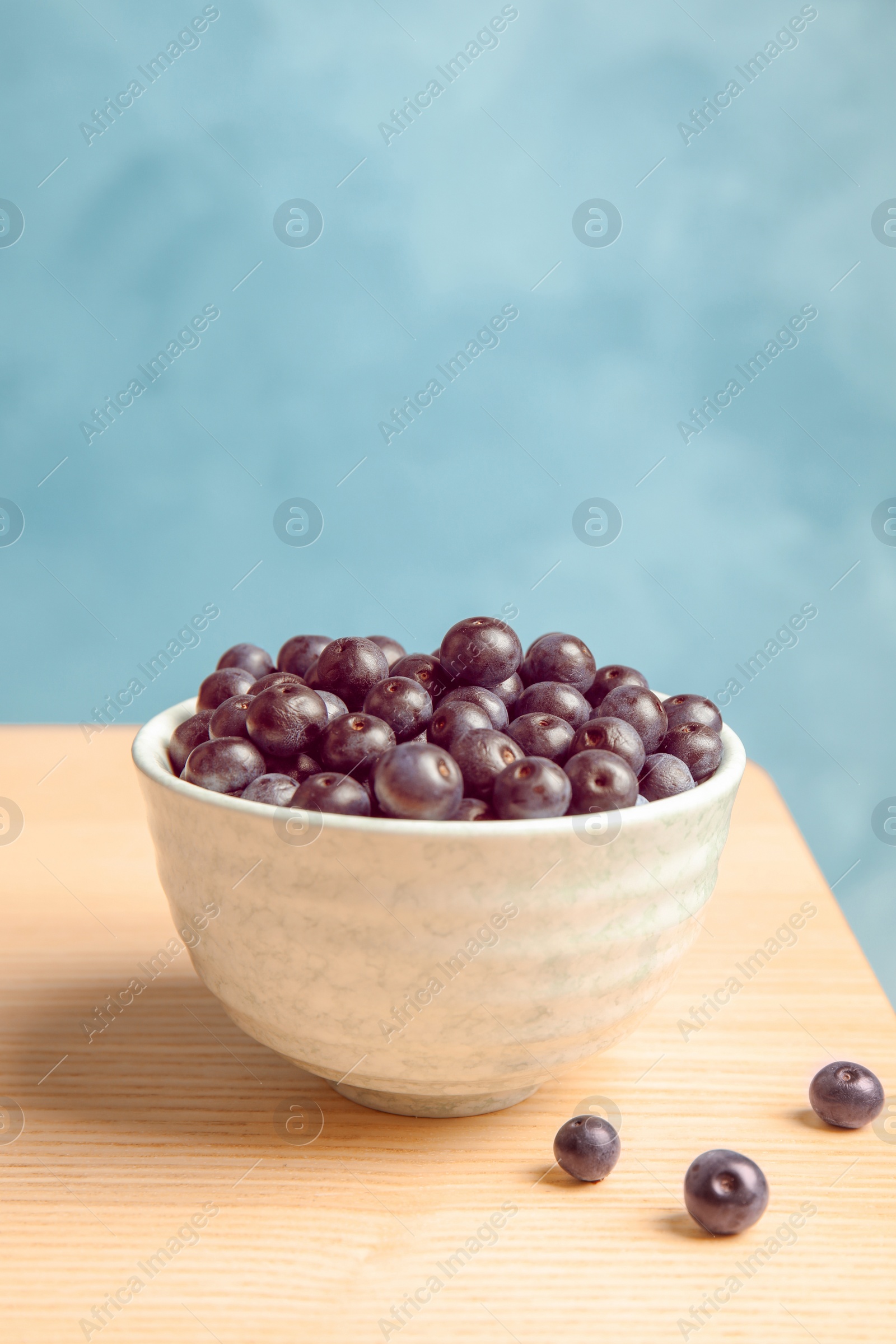 Photo of Bowl with fresh acai berries on table